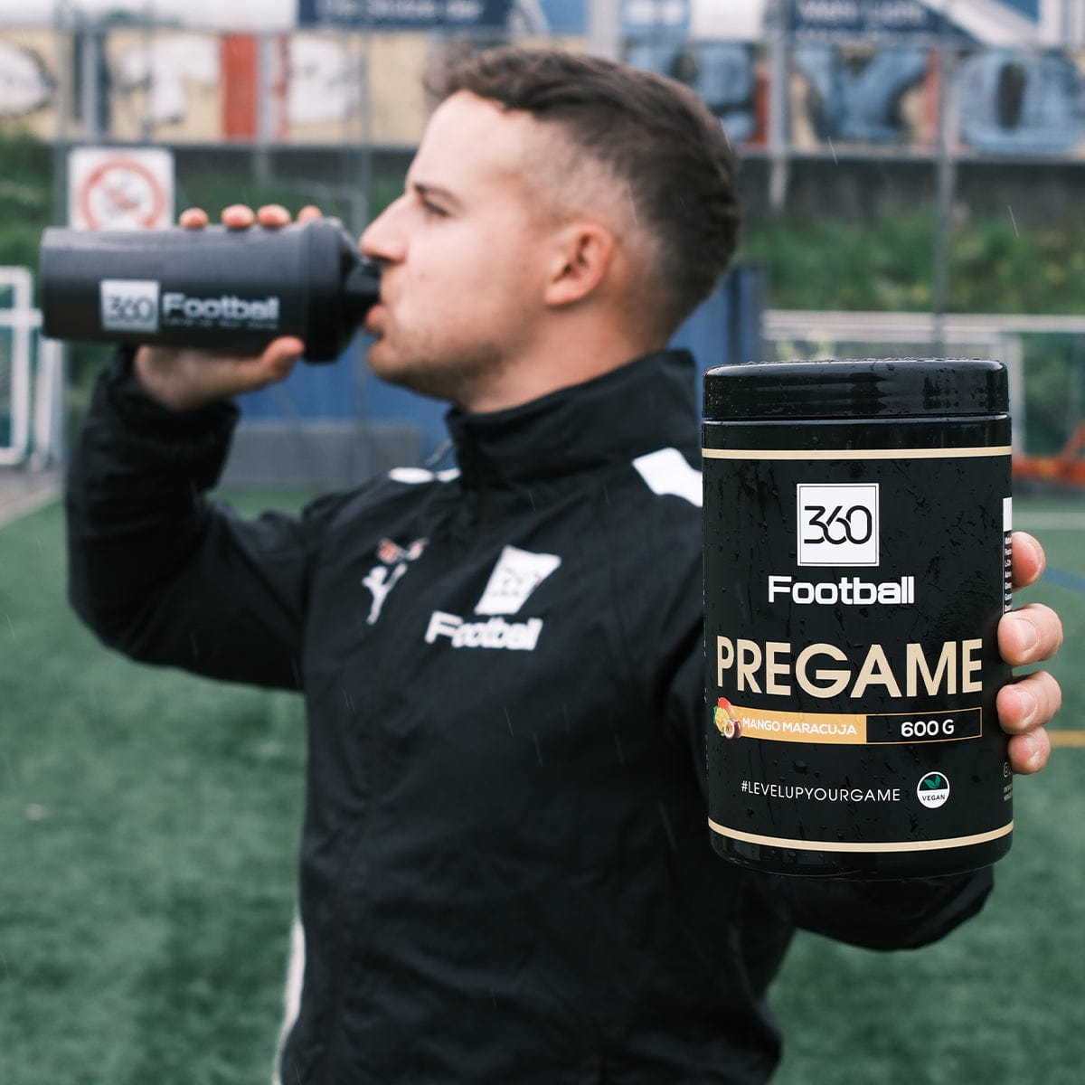 Nic von 360Football trinkt aus einem 360Football Shaker und hält einen Pregame360 Mango Maracuja richtung Kamera