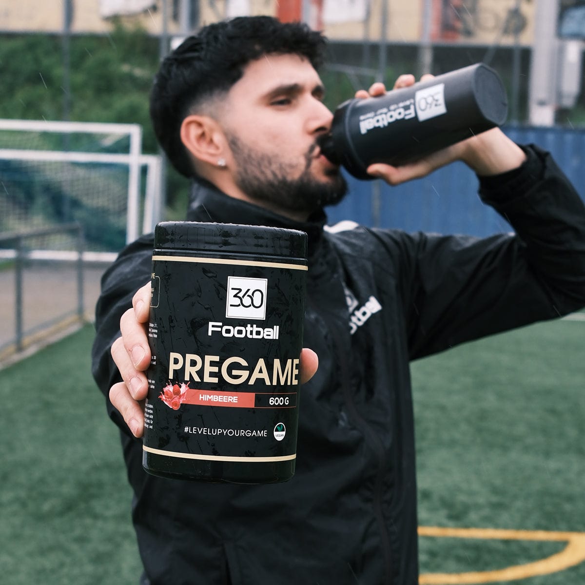Jan Solak von 360Football trinkt aus einem 360Football Shaker und hält einen Pregame360 Himbeere richtung Kamera