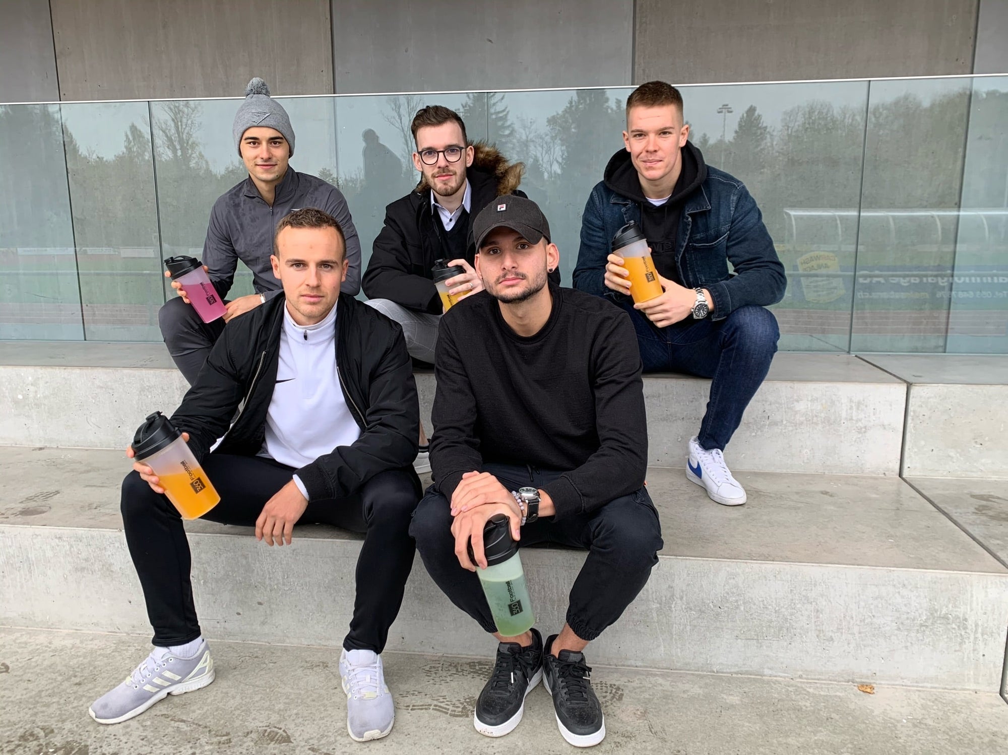 Das ganze 360Football Supplements Team im Hintergrund ist sitzend auf zwei Steinbänken zu sehen