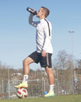 Nic von 360Football trinkt einen Recover360 aus einem 360Football Shaker auf einem Fussballplatz