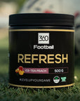 Die Refresh360 steht auf einem Fussballfeld, im Hintergrund sieht man einen Fussball